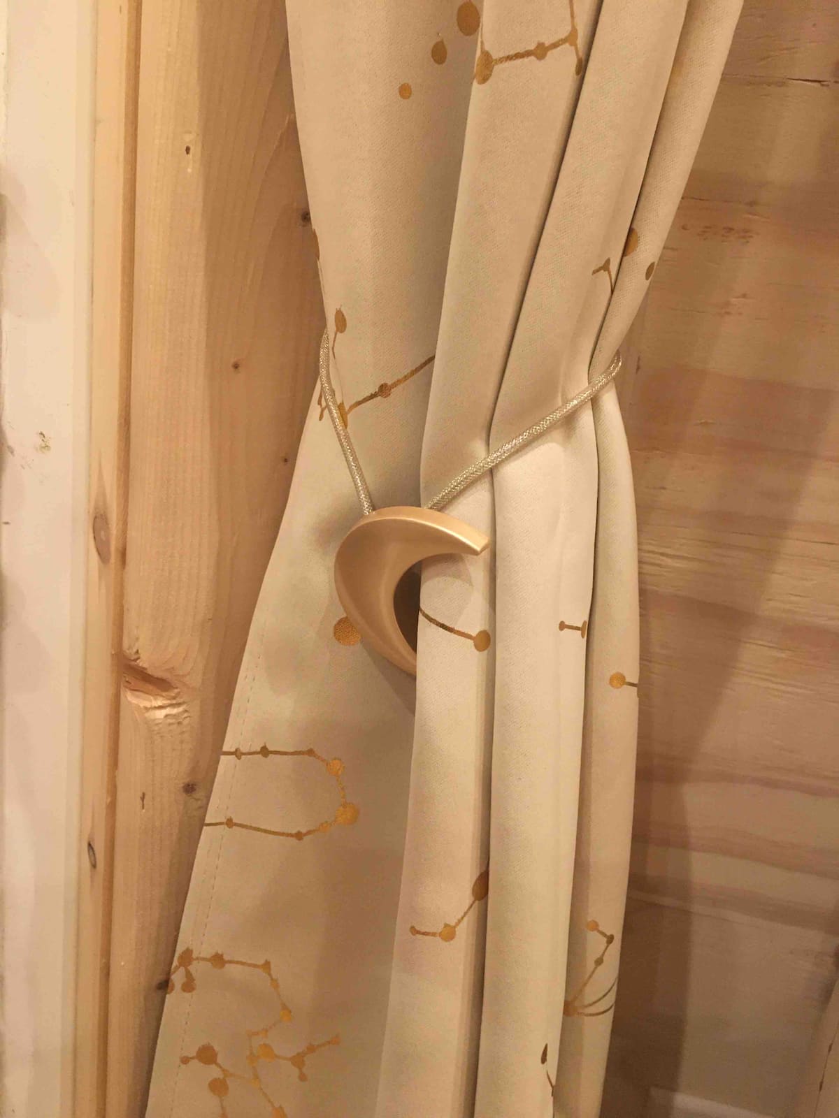 Curtain tied back with a crescent moon