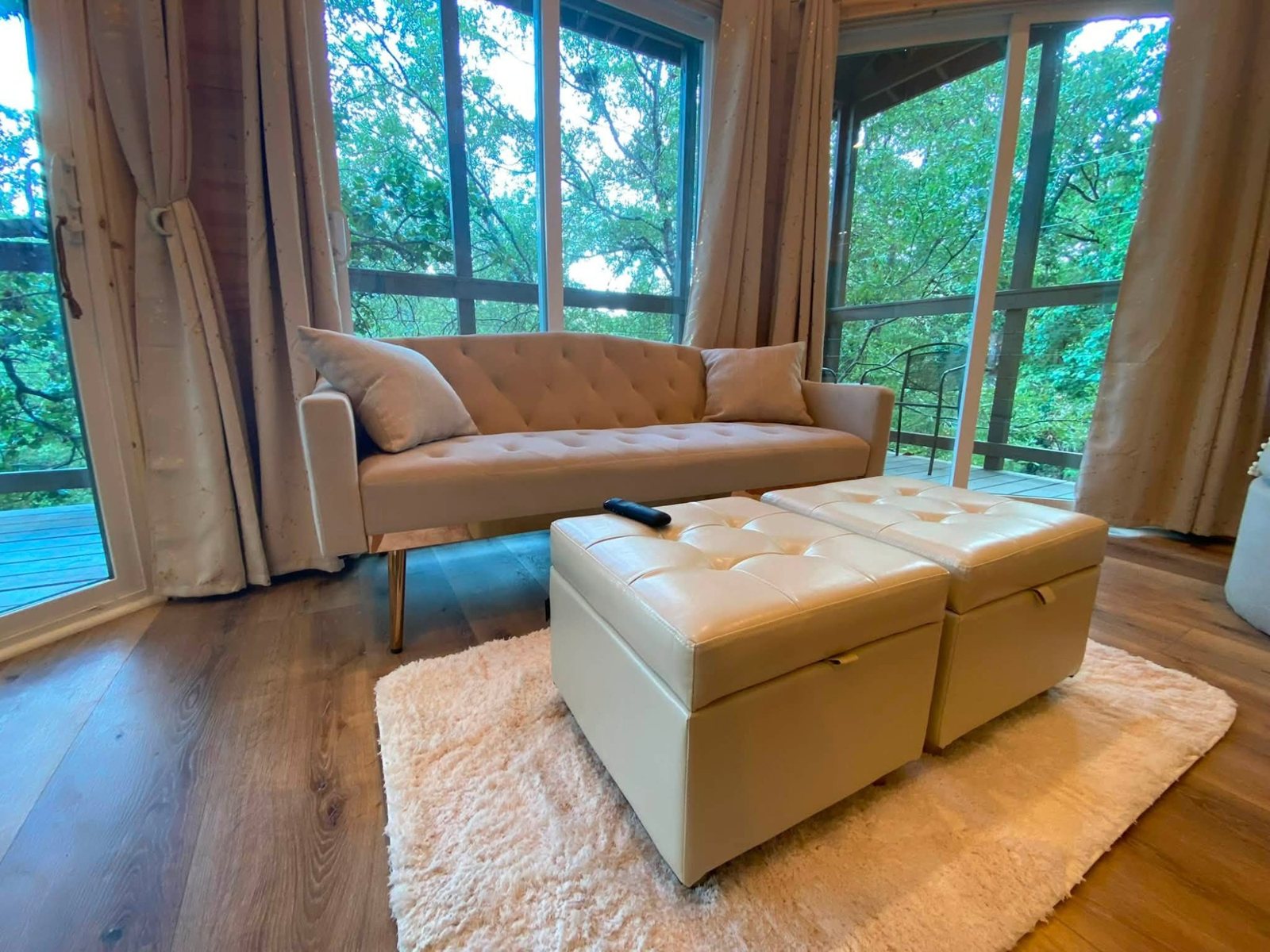Living room with a loveseat and windows onto the veranda